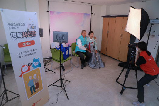 롯데정보통신 샤롯데봉사단원이 어르신들의 사진을 촬영하고 있다.  롯데정보통신 제공